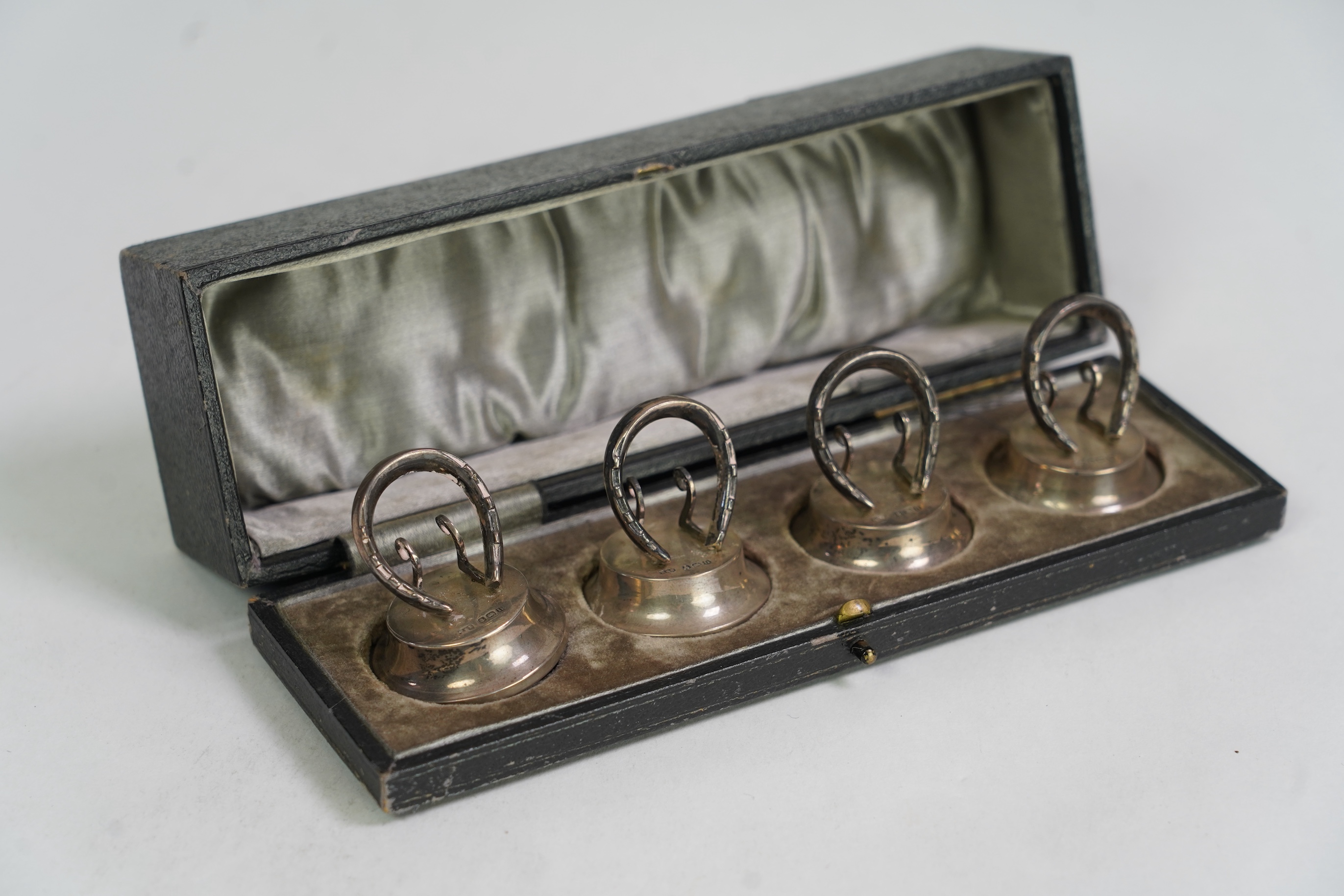 A cased set of four Edwardian silver horseshoe menu holders, by Levi & Salaman